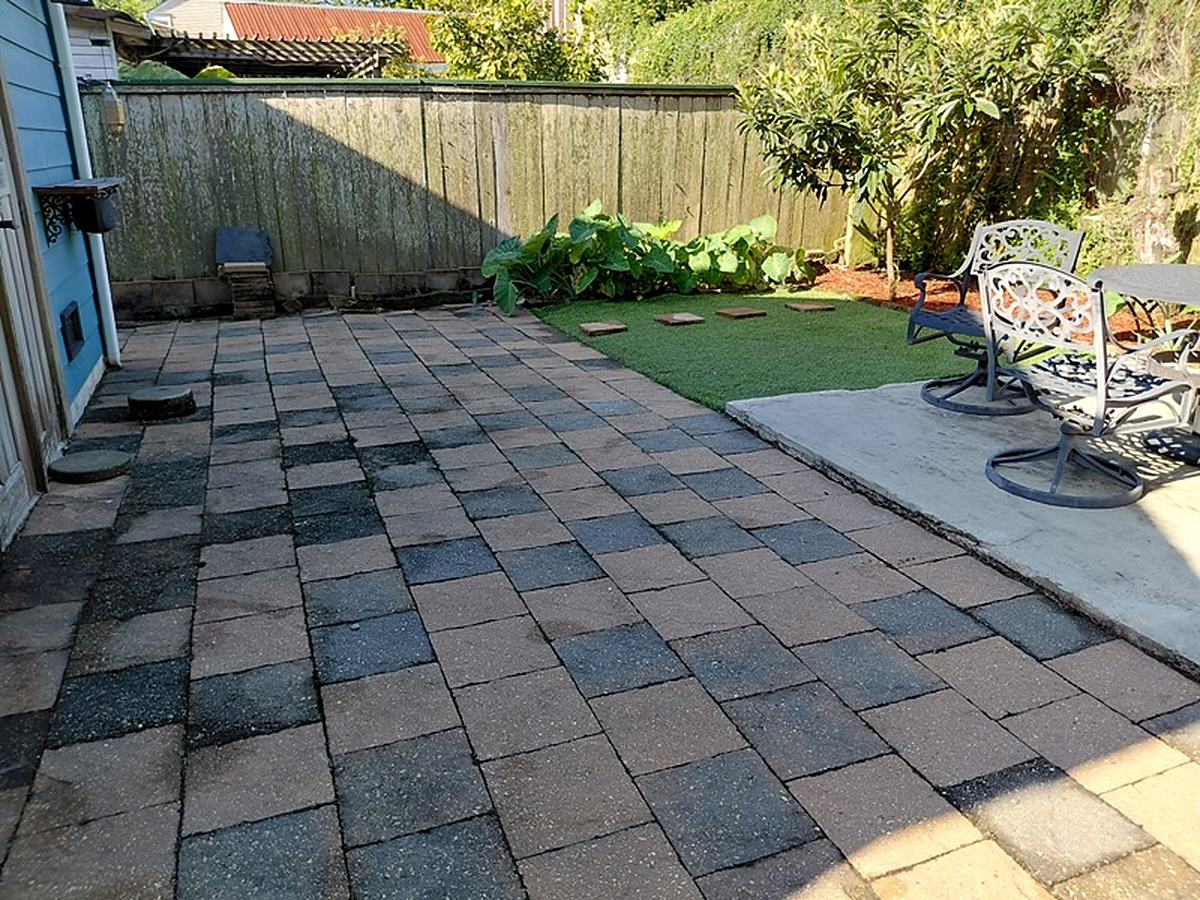 After: the courtyard cleaned up, with a paver patio, turf and stepping stones